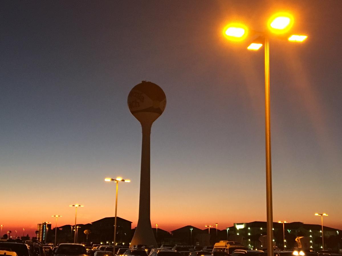 Lights over a parking lot at dusk.